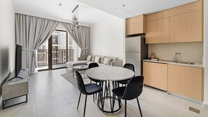 Eine moderne Wohnung mit Essbereich, Küche und einem Balkon mit Vorhängen.