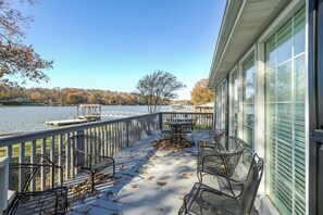 Une terrasse couverte avec des sièges et une vue sur un lac.