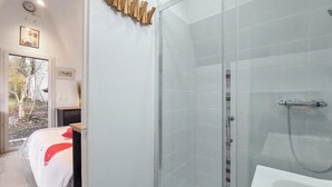 A modern bathroom with a glass shower enclosure, a white sink, and a bed with a red accent. - Awesome home in Herry with heated swimming pool (Herry)
