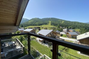 A wooden cabin with a balcony overlooking a village and mountains. - Chalet with infrared sauna (Hohentauern)