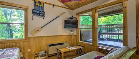 Une cabane équipée d’un lit, d’un chauffage, d’une télévision, d’une pagaie et d’un canoë.