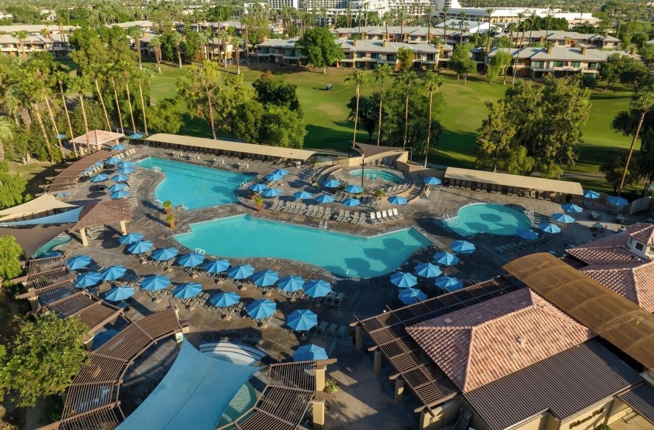 A resort with multiple swimming pools, sun loungers, and umbrellas.