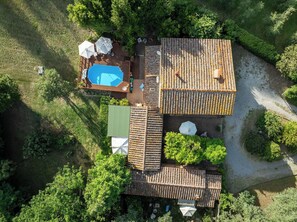 Vue aérienne d’une propriété dotée d’une piscine, d’un espace patio et d’un coin salon extérieur abrité.