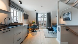 Eine moderne Wohnung mit Küche, Essbereich und einem Balkon mit Blick.