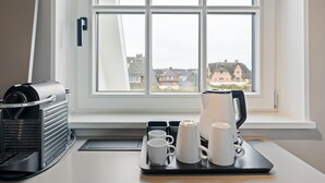 Eine Küche mit Kaffeemaschine, Wasserkocher und einem Tablett mit Tassen.