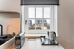 A kitchen with a window, a kettle, mugs, and a tray. - Dependance Windrose 172 - Dependances Windrose (Wenningstedt-Braderup (Sylt))