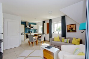Eine moderne Wohnung mit Essbereich, Küche und Wohnzimmer.