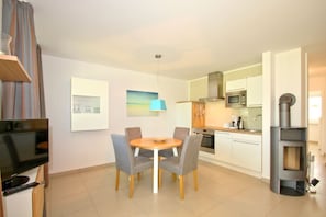 Eine moderne Wohnung mit Essbereich, Küche und Fernseher.