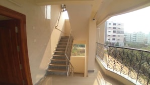 Eine Treppe führt zu einem Balkon mit einem Metallgeländer.