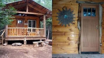 A wooden cabin with a porch, a door with glass panels, and a decorative wall piece.
