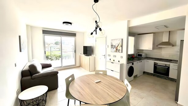 Een moderne keuken met een inbouwoven, magnetron en wasmachine.