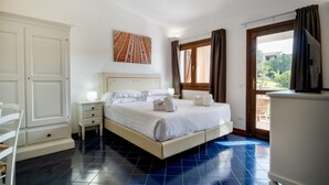 Um quarto com cama, mesa de cabeceira, cômoda e janela com cortinas.