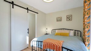 A bedroom with a bed, a bedside table, a lamp, a ceiling fan, and a door. - Flat access - covered boat slip with dock-two car garage - year round water (Spring City)