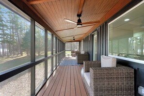 A covered porch with wicker furniture, large windows, and ceiling fans. - Flat access - covered boat slip with dock-two car garage - year round water (Spring City)