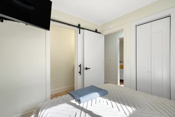 A bedroom with a bed, a sliding door, a television, and a closet. - Flat access - covered boat slip with dock-two car garage - year round water (Spring City)