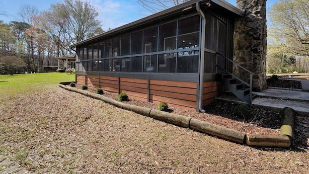A modern building with large windows, a stone chimney, and a wooden deck. - Flat access - covered boat slip with dock-two car garage - year round water (Spring City)