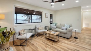 A modern living room with a sofa, chairs, a coffee table, and a large window with a view. - Flat access - covered boat slip with dock-two car garage - year round water (Spring City)