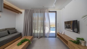 Ein modernes Wohnzimmer mit einer Couch, einem Holztisch, einem Fernseher und Blick auf einen Pool.