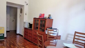 A dining area with a round table and four wooden chairs. A wooden cabinet with glass doors is in the background. - Comfortable rooms in the heart of Vomero, just a few meters from the subway. (Napoli)