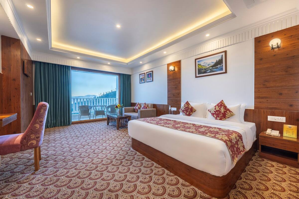 Une chambre d’hôtel avec un grand lit, un bureau, une chaise et une vue sur le paysage urbain.