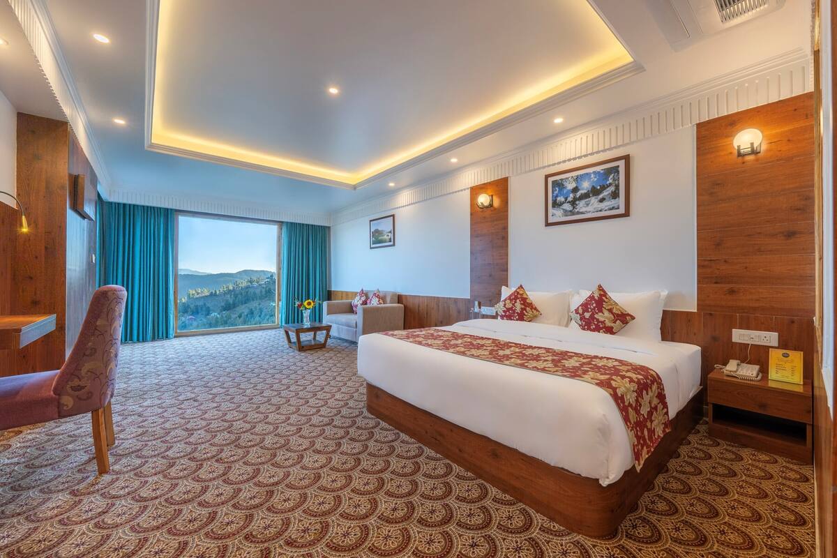 Une chambre d’hôtel avec un grand lit, un bureau, une chaise, une vue sur l’extérieur et un mur décoratif en bois.