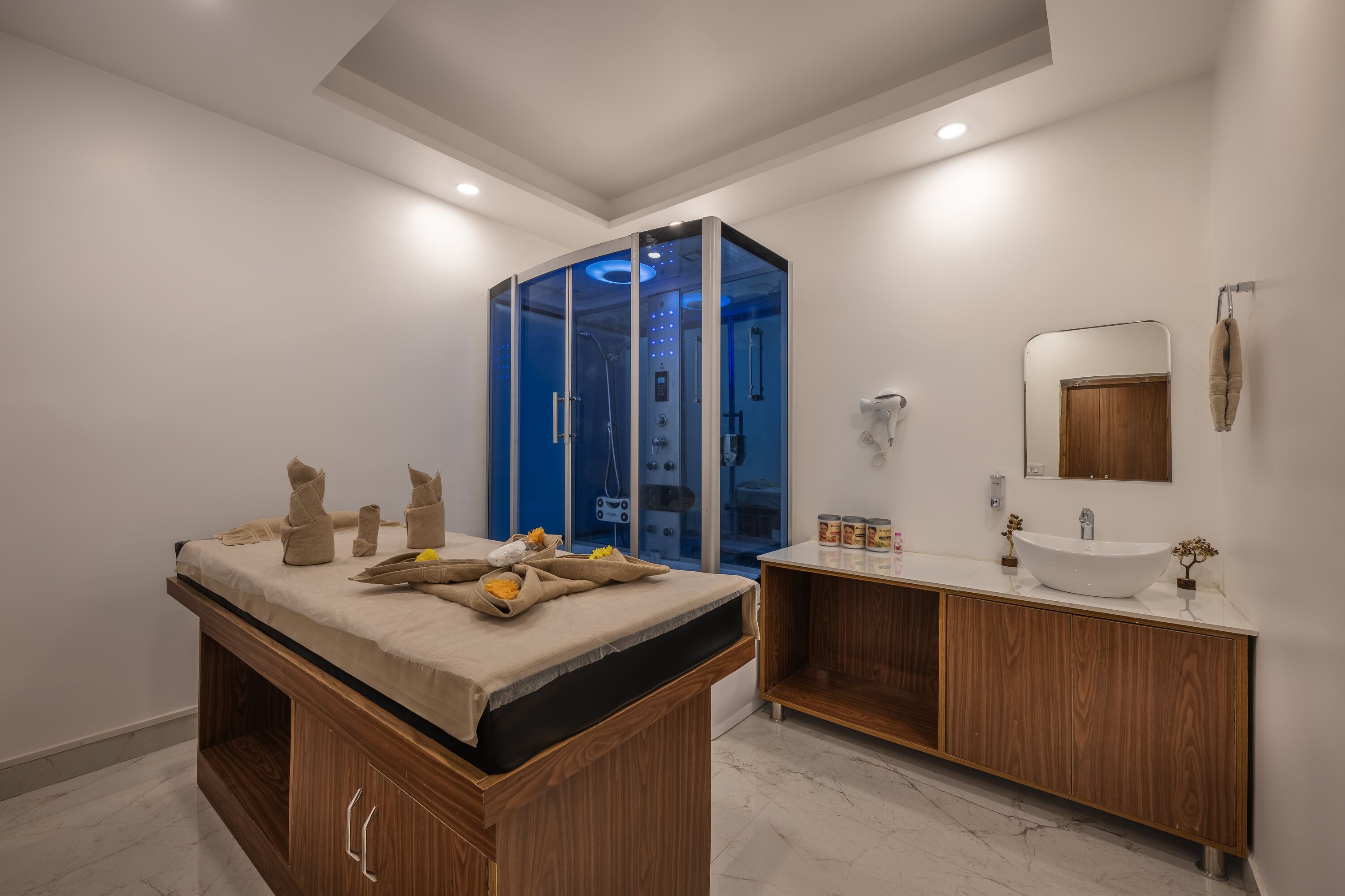 Un baño moderno con cabina de ducha de vidrio, tocador de madera y un espejo grande.