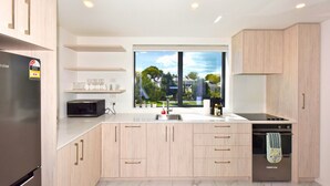 A modern kitchen with a built-in microwave, a dishwasher, and a large window offering a view of the outdoors.