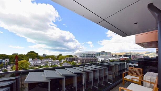 A modern building with a glass balcony overlooking a cityscape. - Fresh 1 Bedroom Apartment Close to Te Kaha Stadium (Christchurch)