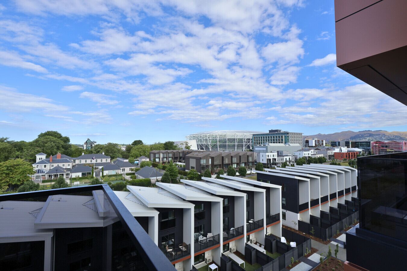A modern building with multiple floors, large windows, and a flat roof.