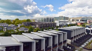 A modern urban area with residential buildings, a large glass structure, and a stadium. - Fresh 1 Bedroom Apartment Close to Te Kaha Stadium (Christchurch)