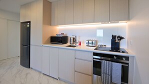 A modern kitchen with a built-in microwave, toaster, and oven. - Fresh 1 Bedroom Apartment Close to Te Kaha Stadium (Christchurch)