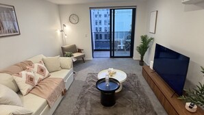 Un salon moderne avec un canapé, une table basse et un téléviseur.