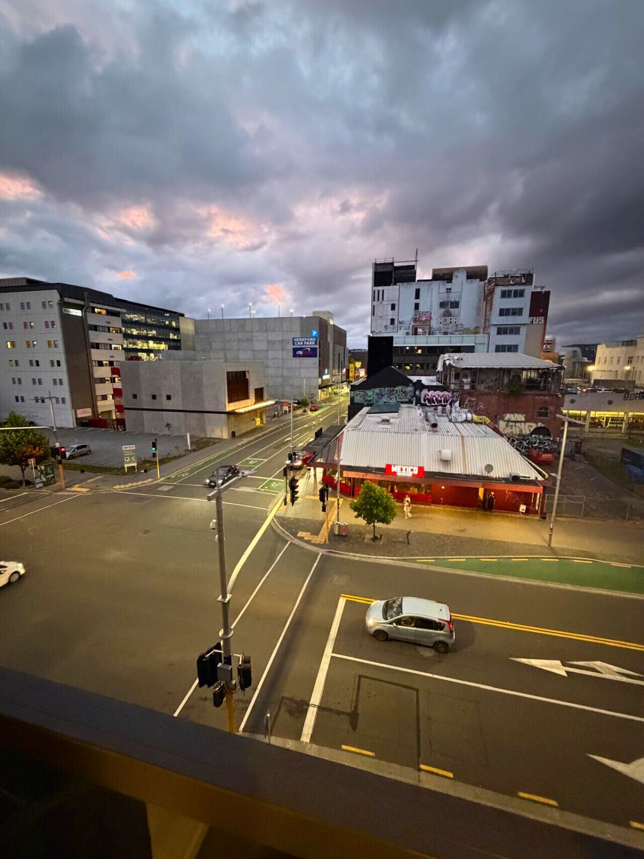 A city intersection with buildings, a car park sign, and a Mexican restaurant.