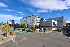 Una intersección urbana con un edificio moderno identificado como 'HEREFORD CAR PARK' y un carril bici verde.