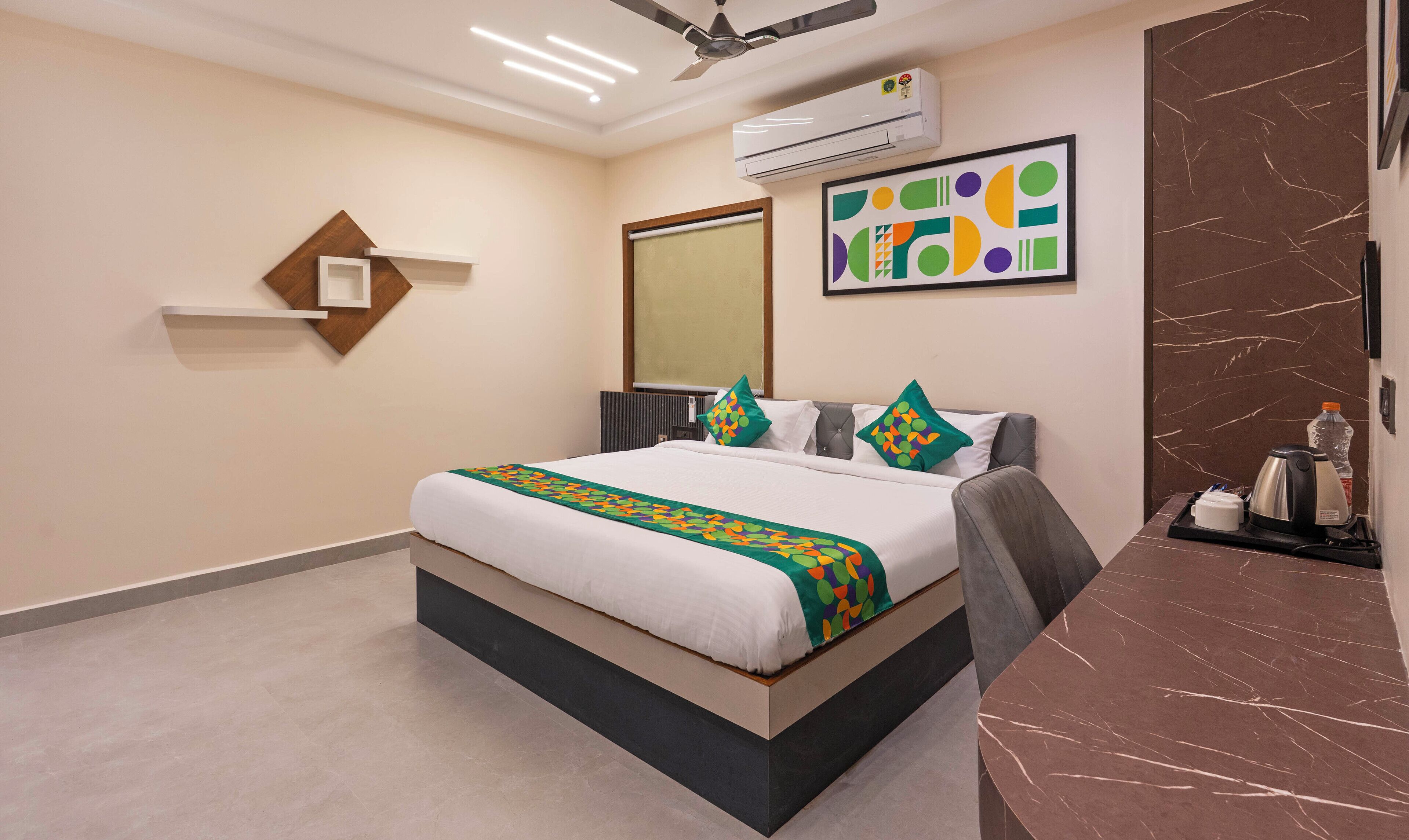 Une chambre d’hôtel avec un lit, un bureau, un climatiseur et un mur en marbre.