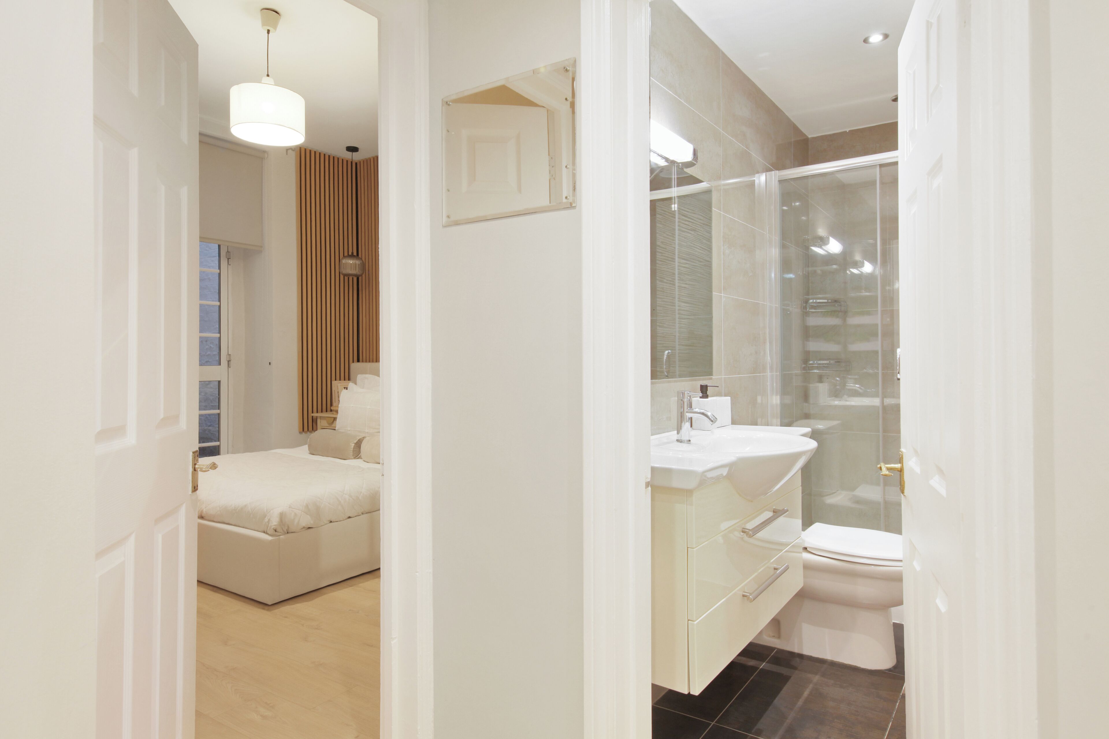 A modern bathroom with a glass shower enclosure, a white sink, and a toilet.