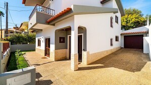 Een twee verdiepingen tellend huis met een balkon, een garage en een kleine tuin.