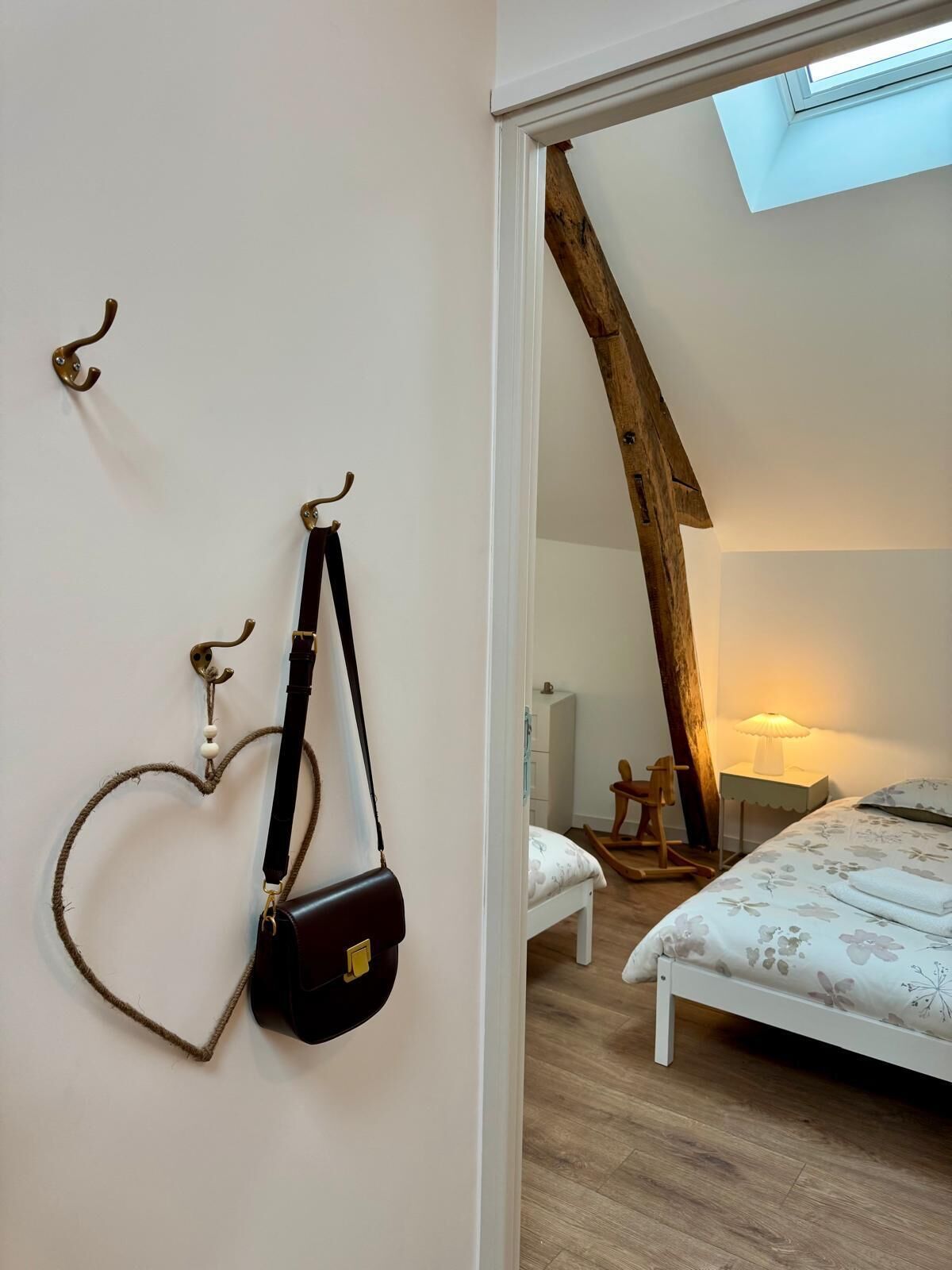 A bedroom with a bed, a desk, a chair, and a skylight.