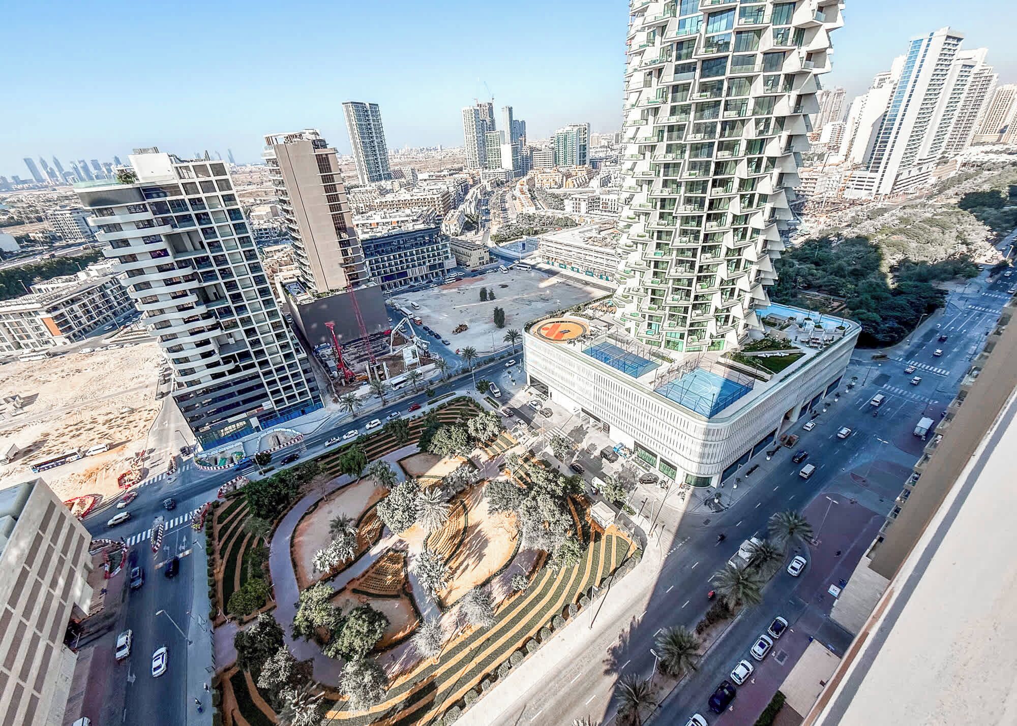 Un edifici de grans alçades amb disseny modern, envoltat d'altres edificis alts i un carrer bullició.