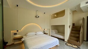 A modern bedroom with a large bed, a bunk bed, a staircase, and a unique clock on the floor. - zz's hotel (Haikou)