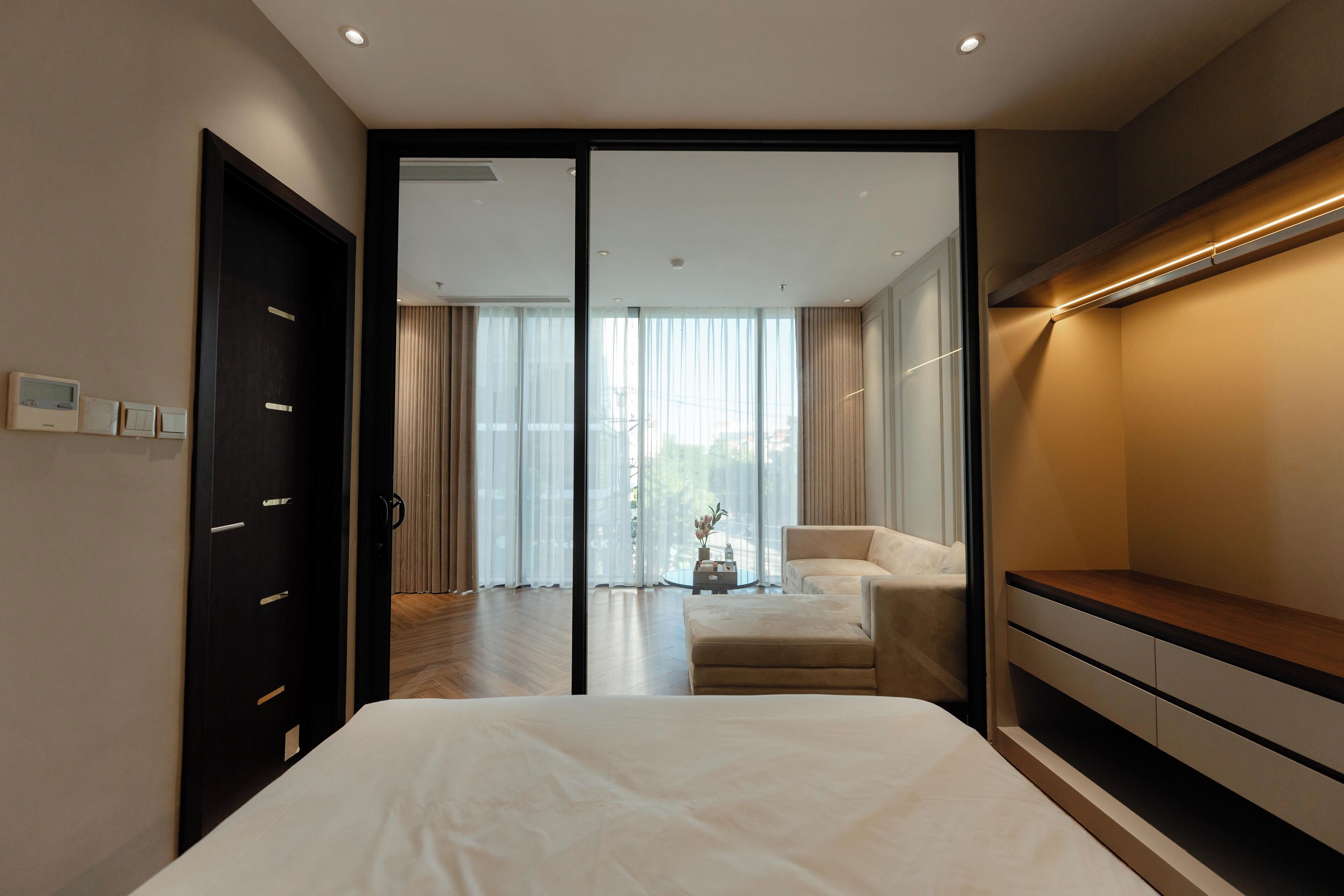 Un dormitorio moderno con una cama grande, un sofá y un mueble para televisión.