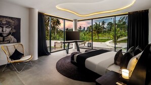 A modern bedroom with a large bed, a TV, a chair, and a view of the outdoors. - 12 Bedroom Myosotis VVV (Ubud)