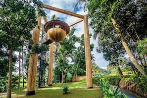 A garden with a wooden structure, bamboo pillars, and a circular wooden platform. - 12 Bedroom Myosotis VVV (Ubud)