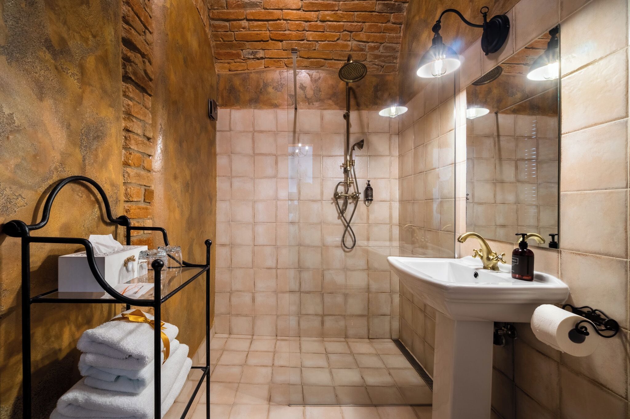A bathroom with a shower, a sink, and a towel rack.