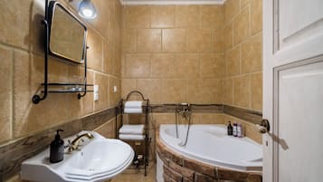 A bathroom with a sink, mirror, towel rack, and a bathtub.