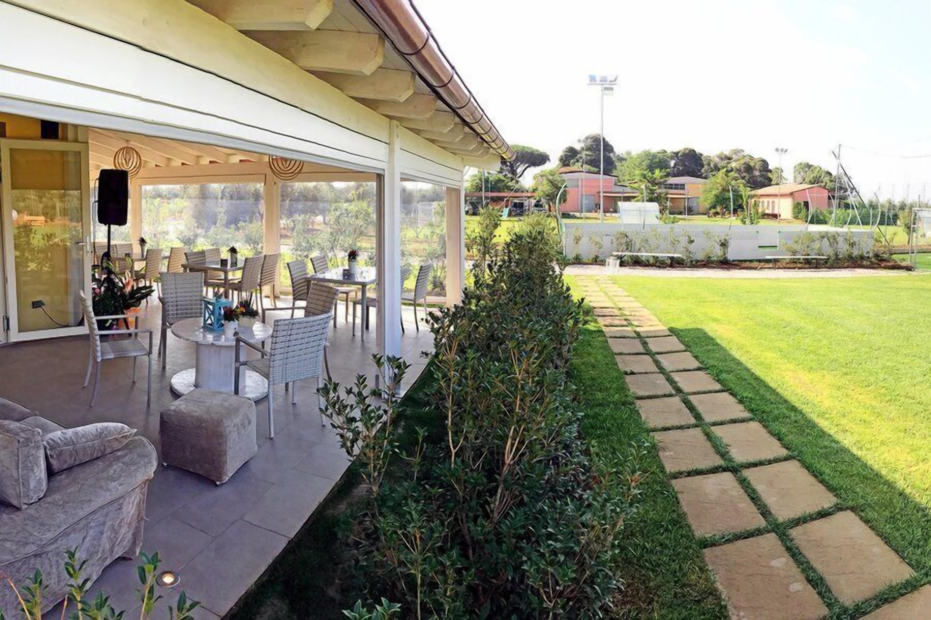 An outdoor patio with seating, a lawn, and a stone pathway.