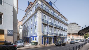 A multi-story building with a blue facade, multiple balconies, and a ground-level entrance. - Ando Living - Abrantes Flats - 23 (Lisbon)