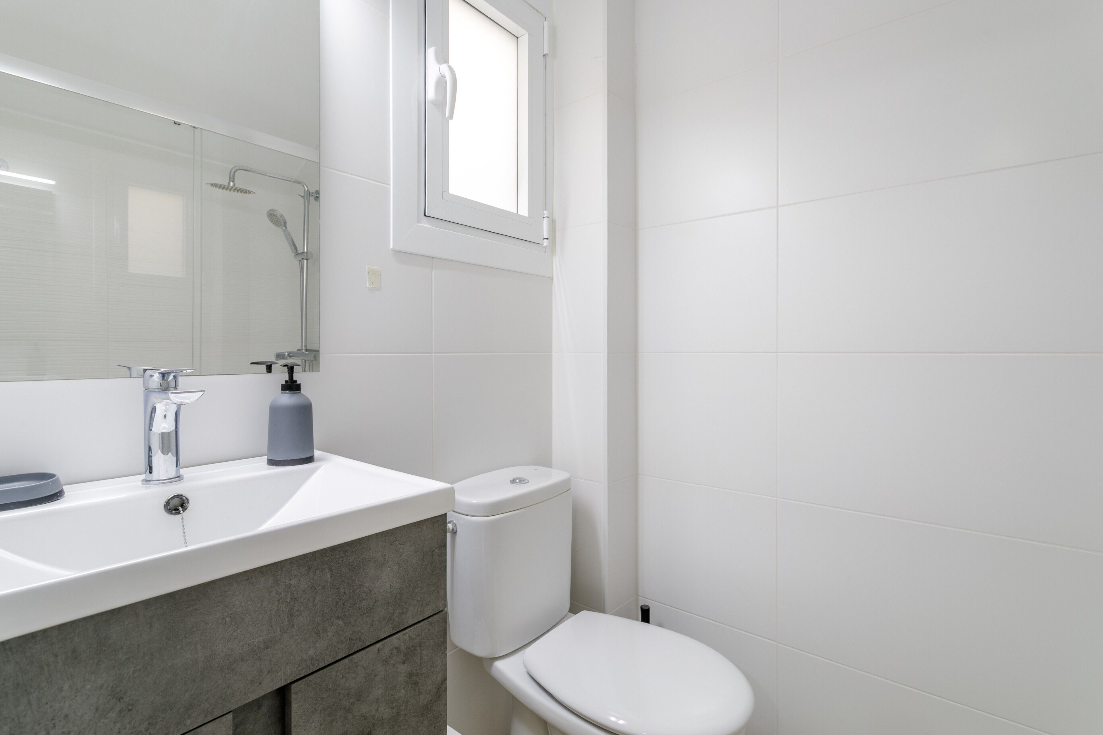 Un baño con lavamanos blanco, inodoro y ducha.
