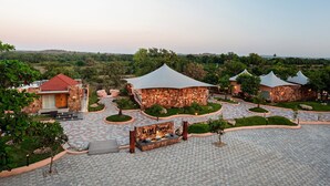 Un resort con edificios de piedra, un patio empedrado y un letrero que dice 'Wild Forest'.