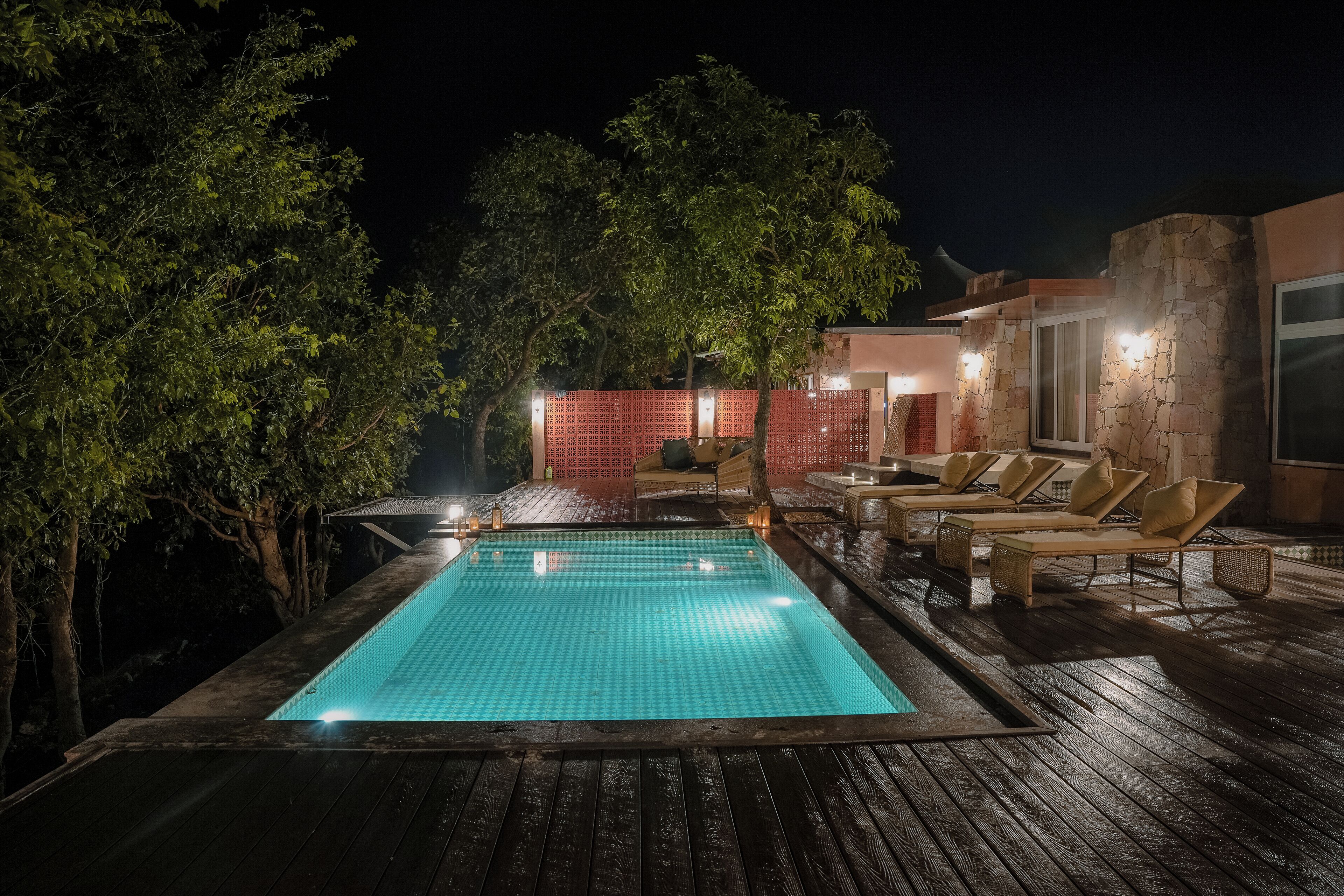 Ein Pool im Freien mit Liegestühlen und einer Holzterrasse.
